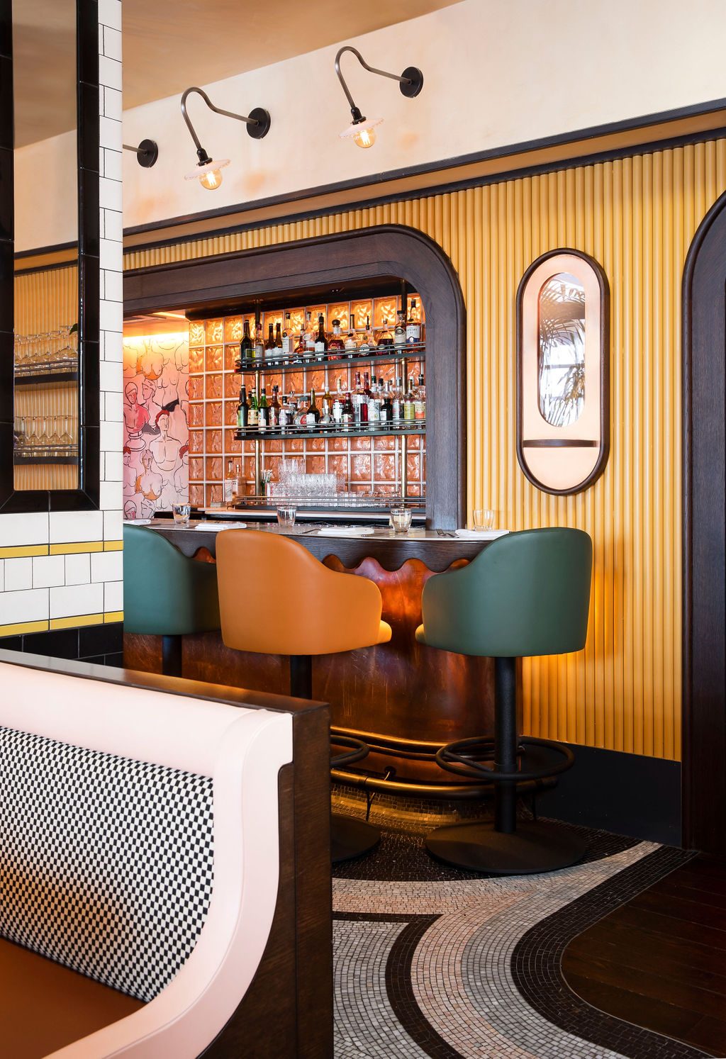 Rochambeau's bar, with green and amber stools in front of the lit back bar.